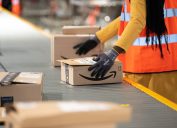 Amazon worker handling package in warehouse