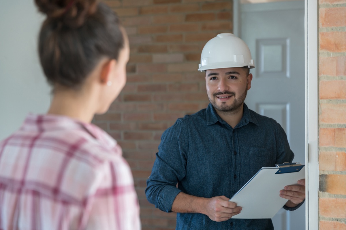 woman greeting a contractor at the door – home addition concepts