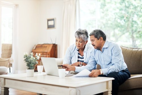 Fotografie cu un cuplu de bătrâni folosind un laptop împreună acasă