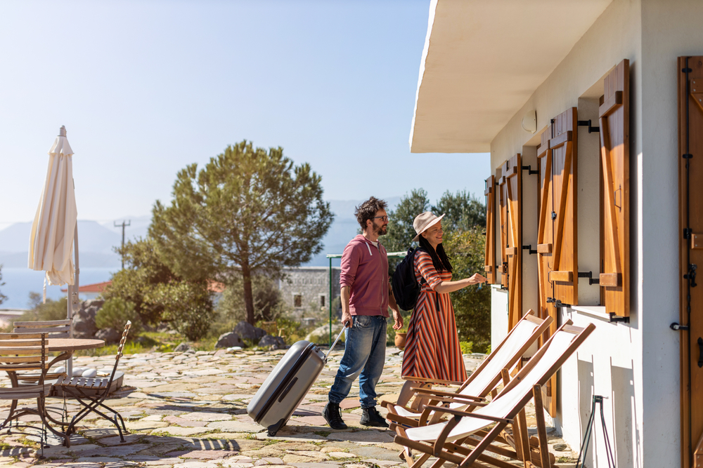 A couple entering a rental home on a sunny day