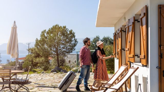 A couple entering a rental home on a sunny day