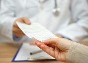 doctor handing prescription to patient