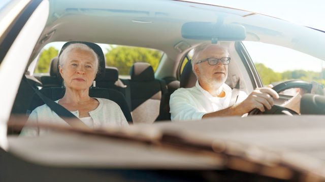Older couple driving in car