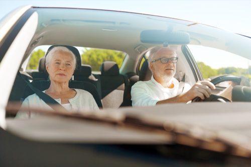 Older couple driving in car