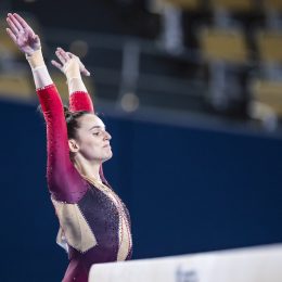 Olympic gymnast Pauline Schäfer in action on beam in a unitard.