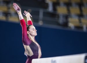 Olympic gymnast Pauline Schäfer in action on beam in a unitard.