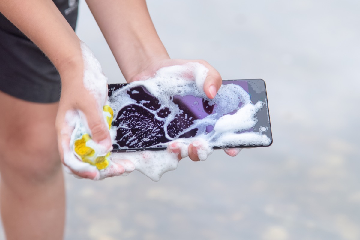 cell phone in the hands is wet and in the foam