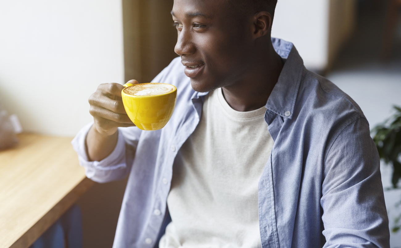 A young man drinking a cup of coffee