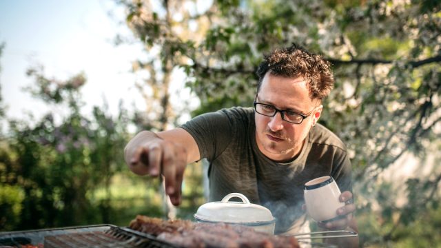 Man cooking for family having barbecue party in summer