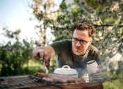 Man cooking for family having barbecue party in summer