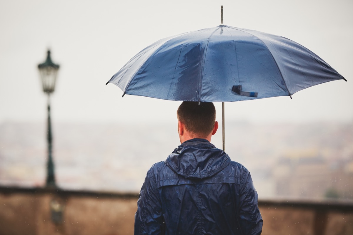 man holding umbrella outside in rain