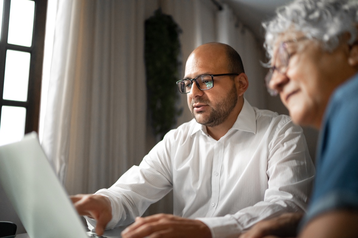 Advisor helping a senior woman at home (or mother and son)