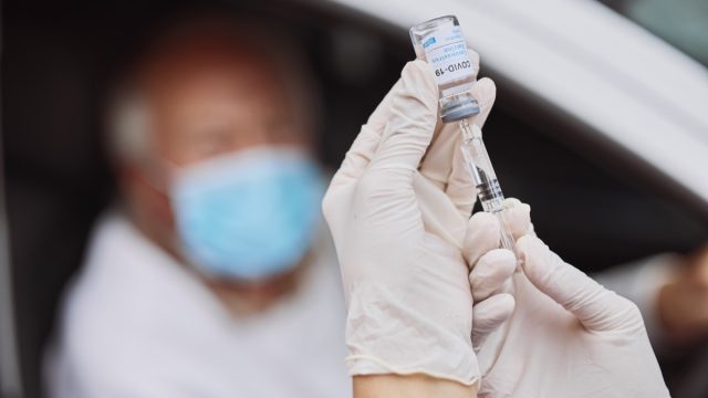 Shot of an unrecognizable healthcare worker extracting liquid from a vial with a syringe at a drive through vaccination site