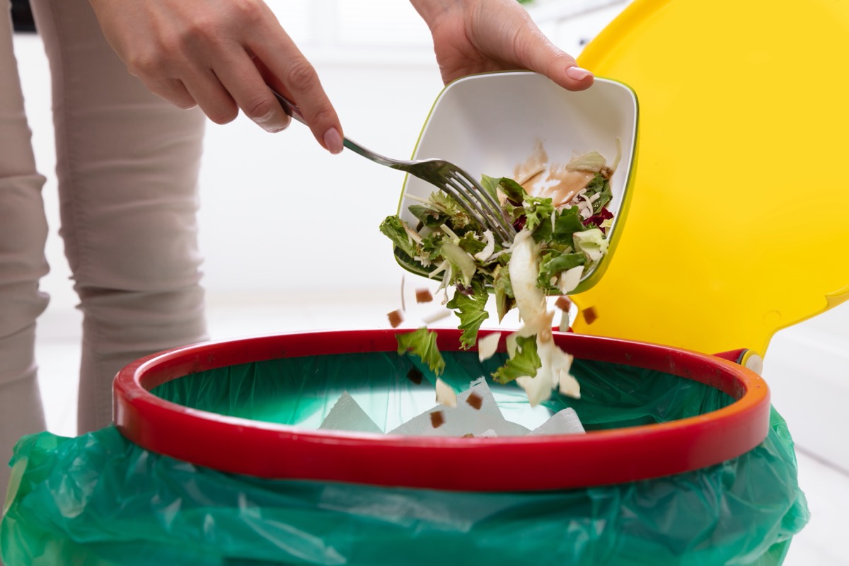 woman throwing away salad