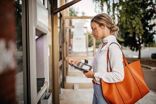 Women using ATM machine to withdraw money