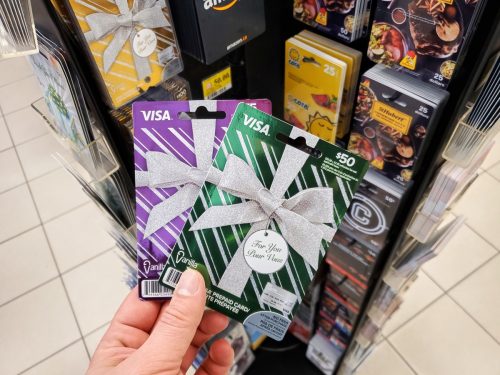 Montreal, Canada - March 22, 2020: Visa gift card in a hand over gift cards background. Visa is an American multinational financial services corporation headquartered in Foster City