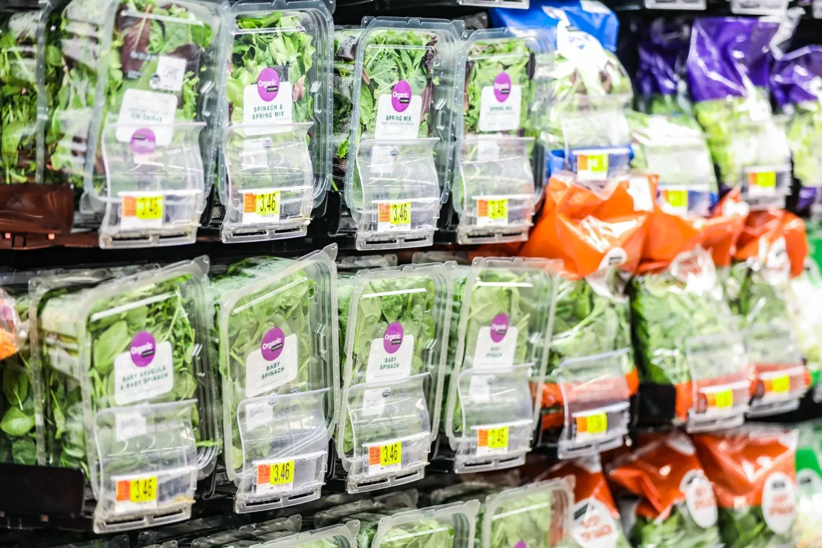 Organic packaged green vegetable mixes; including baby spinach, spring mix, and arugula; at a local Walmart Supercenter store. â€