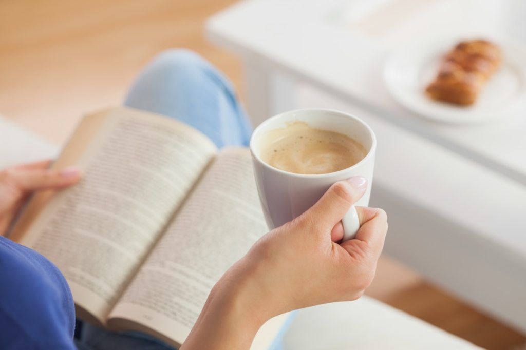 woman drinking coffee and reading