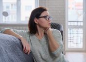 mature woman sitting on the floor at home, sad middle-aged woman alone experiencing health problems and personal troubles