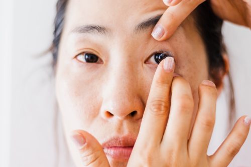 woman in her 30s or 40s putting in contact lens
