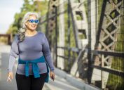 A senior woman walking across a bridge for exercise