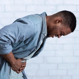 young man bent over with stomach pain