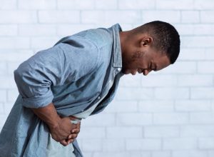 young man bent over with stomach pain