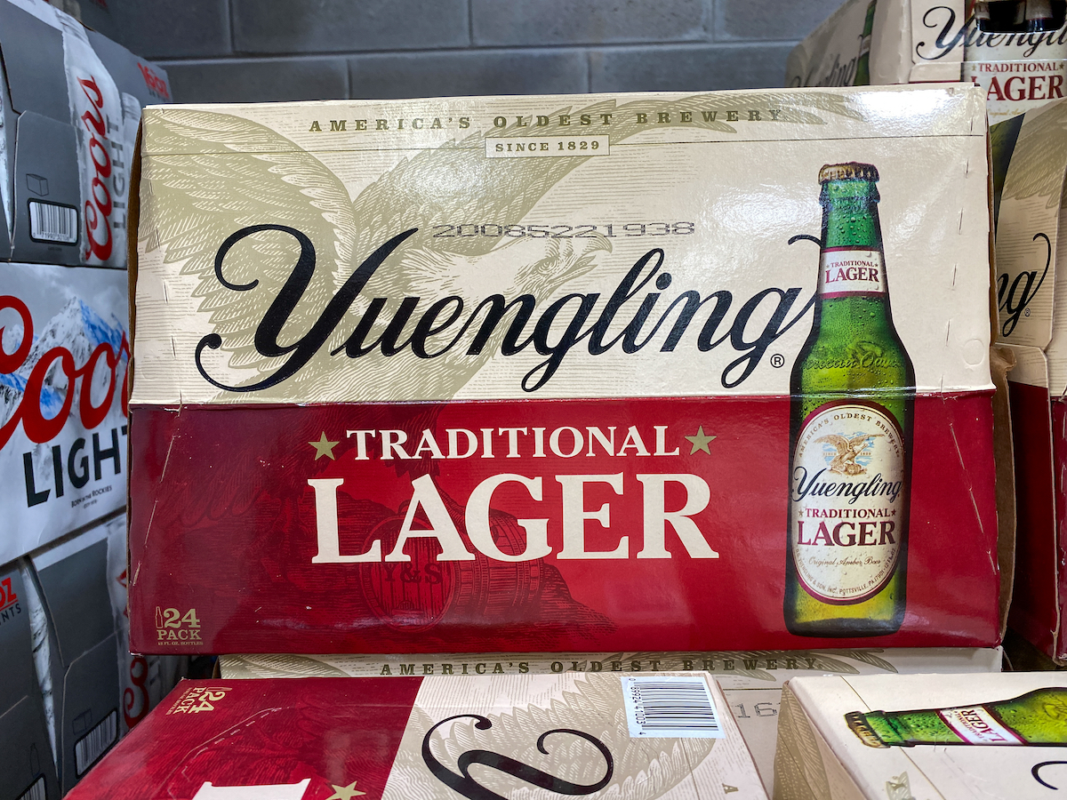 Cases of bottles of Yuengling Traditional Lager at a grocery store waiting for customers to purchase.