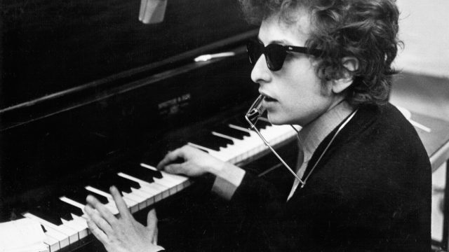 Bob Dylan 1965 at a piano with sunglasses