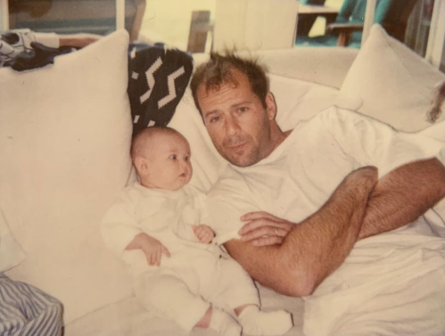 Rumer Willis as a baby with dad Bruce Willis wearing matching white outfits