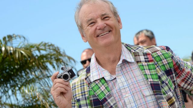 bill murray in green plaid jacket holding tiny camera