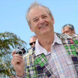 bill murray in green plaid jacket holding tiny camera