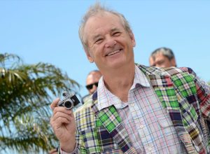 bill murray in green plaid jacket holding tiny camera