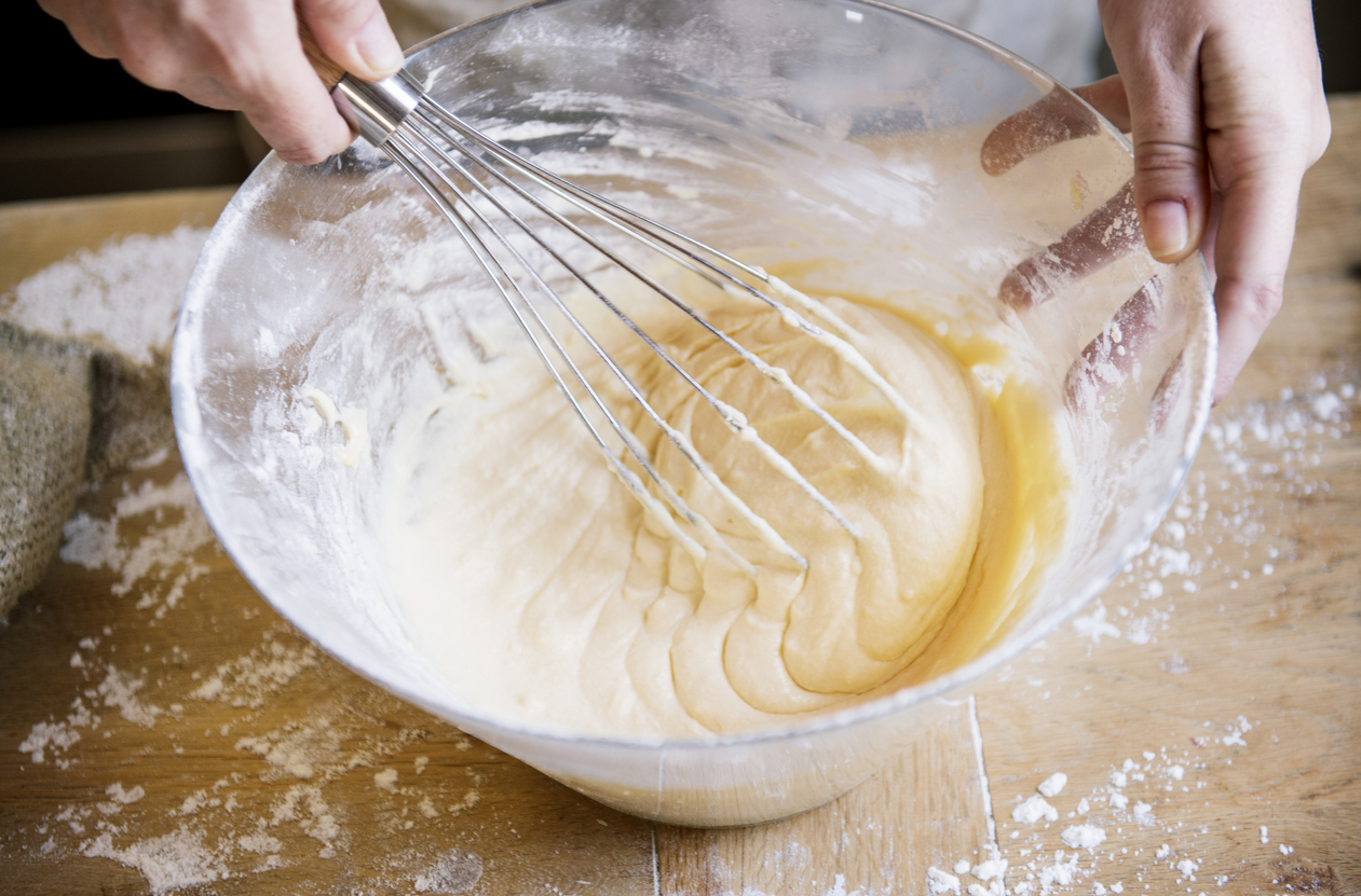 A closeup of a bowl of cake mix being made into batter