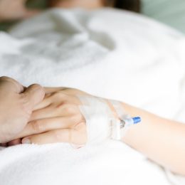 Holding hand in hospital bed