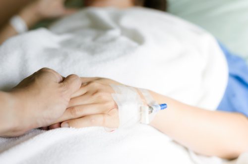 Laikydamas ranką ligoninės lovoje