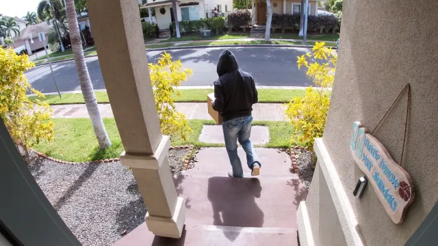 Man stealing packages off porch