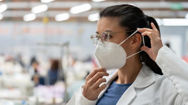female virus expert putting on masks