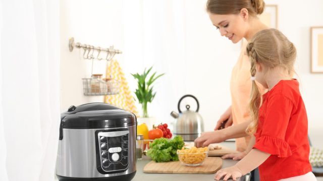 Woman and daughter cooking vegetables in Instant Pot or multi-cooker