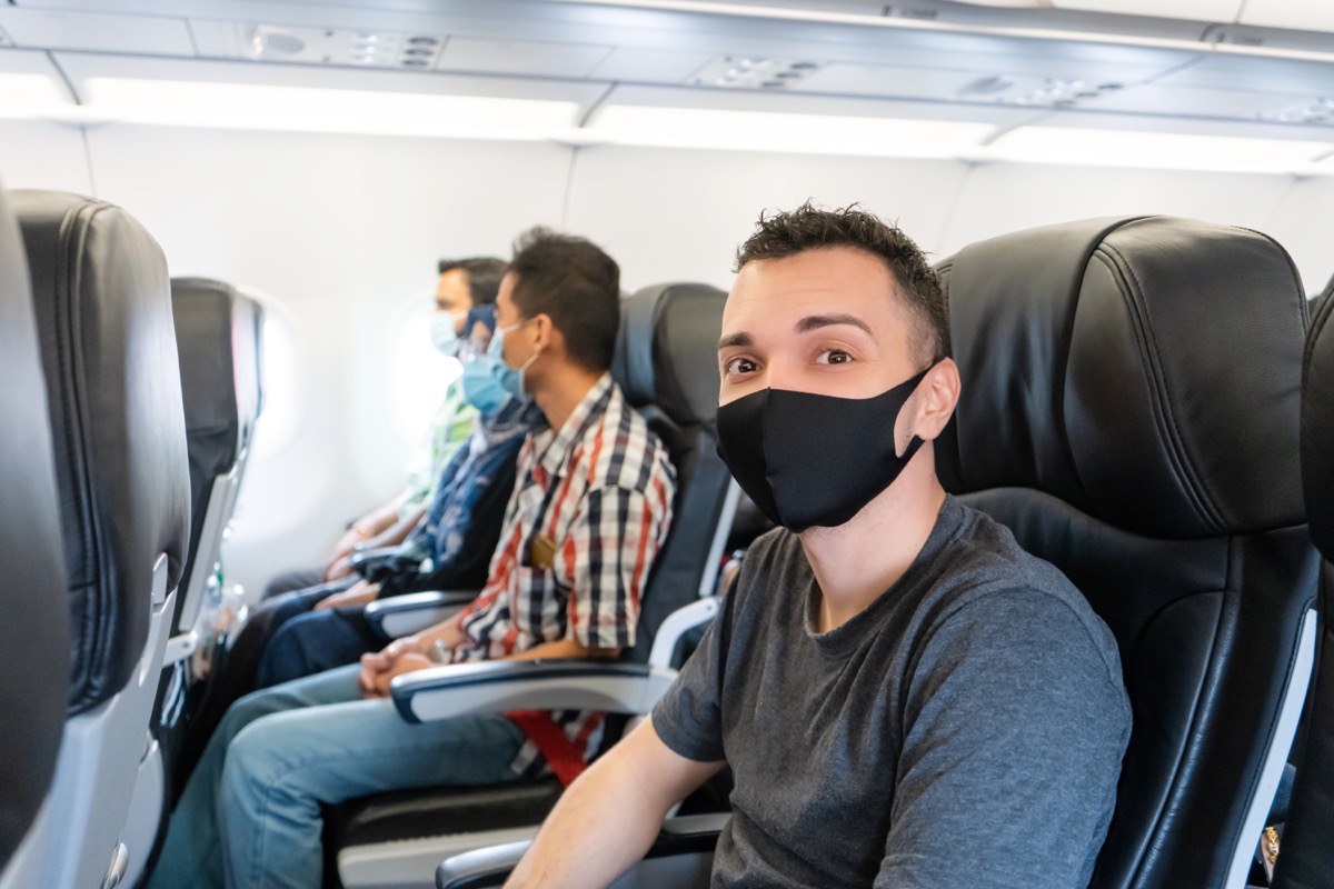 Passagiere des Flugzeugs tragen medizinische Masken im Gesicht.  Flugreisen während der Coronavirus-Pandemie.  Anforderungen der Fluggesellschaften