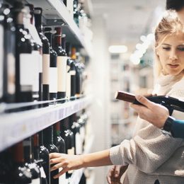 A young couple shopping for a bottle in a liquor store