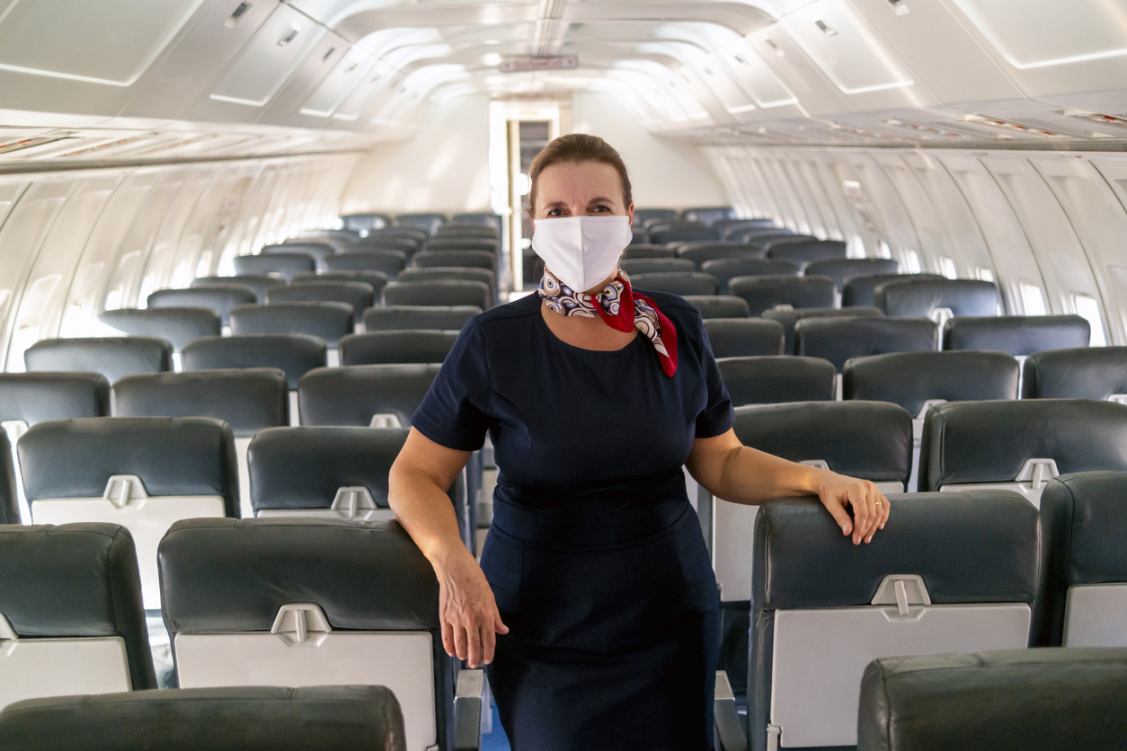 A flight attendant wearing a face mask onboard an empty plane