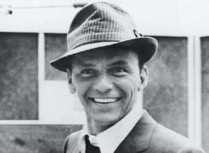 American singer and actor Frank Sinatra smiles at recording studio, 1950s.