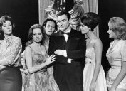 sean connery in black suit surrounded by women in james bond movie thunderball in a black and white still