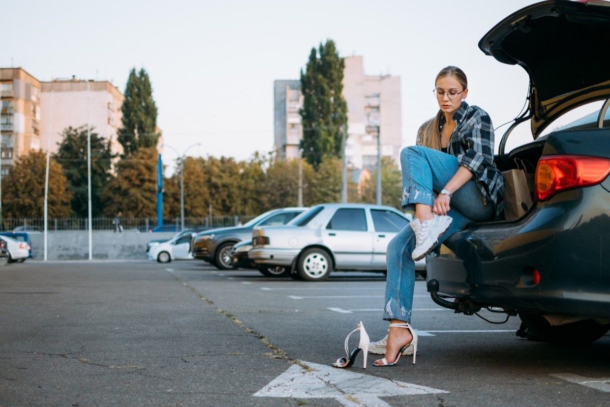 Woman changing shoes after driving