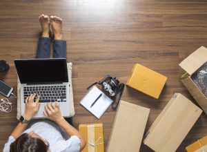 Person on computer surrounded by deliver boxes