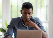 millennial male employee look at laptop screen working