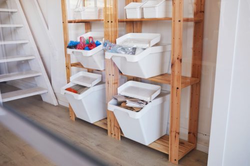 white storage bins on wooden rack in basement