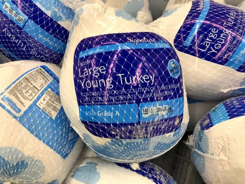 Alameda, CA - Nov 13, 2019: Grocery store freezer shelf with Signature farms brand frozen turkeys. The most common main dish of a Thanksgiving dinner.