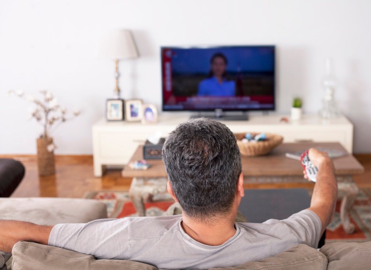 ソファの上でテレビを見ている男